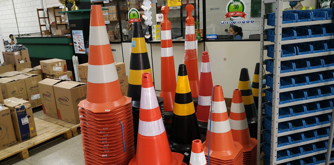 Área da loja Cobequi com cones de sinalização, caixas de estoque e organizadores